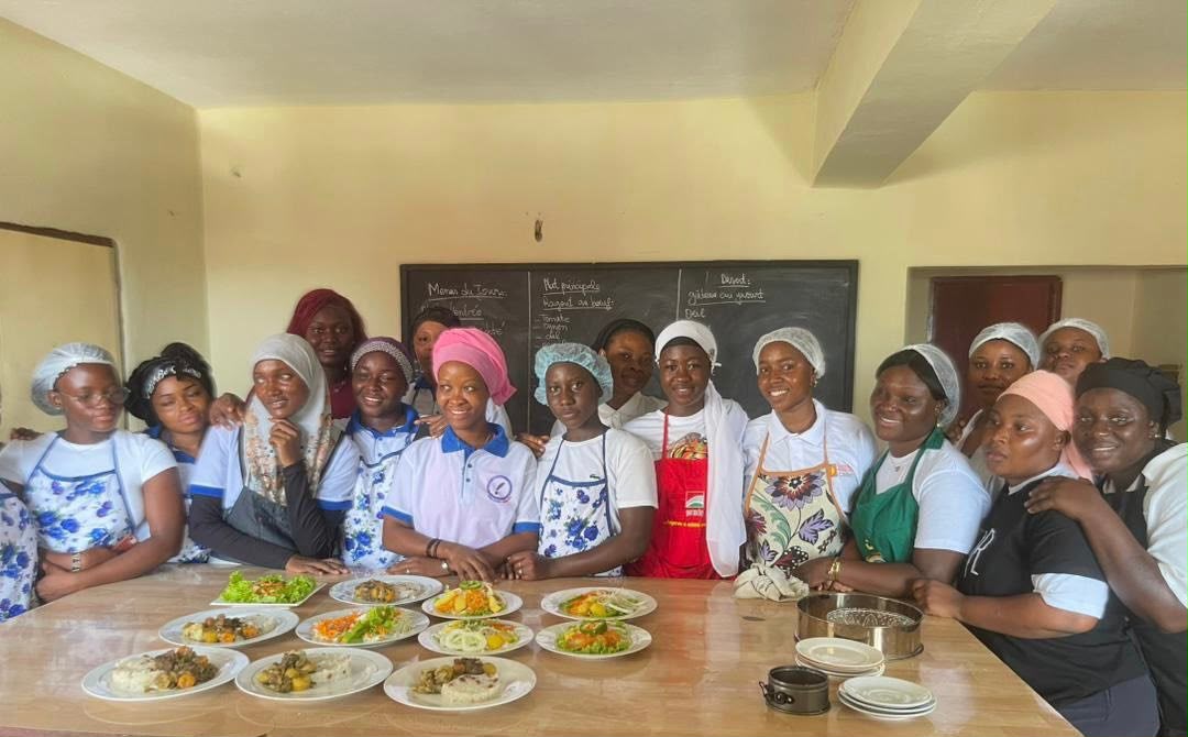 Apprenantes d'ADEFOR réunies autour de leurs réalisations pendant un cours pratique de cuisine
