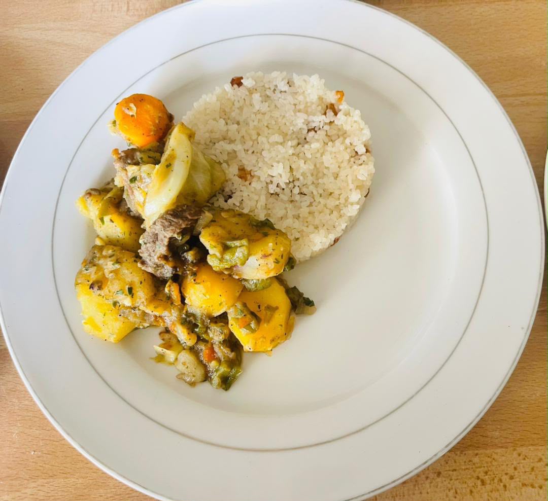 Riz servi avec une préparation de viande et légumes dans une assiette blanche